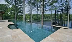 Geometric pool with turquoise water, travertine deck, and modern glass pergola structure