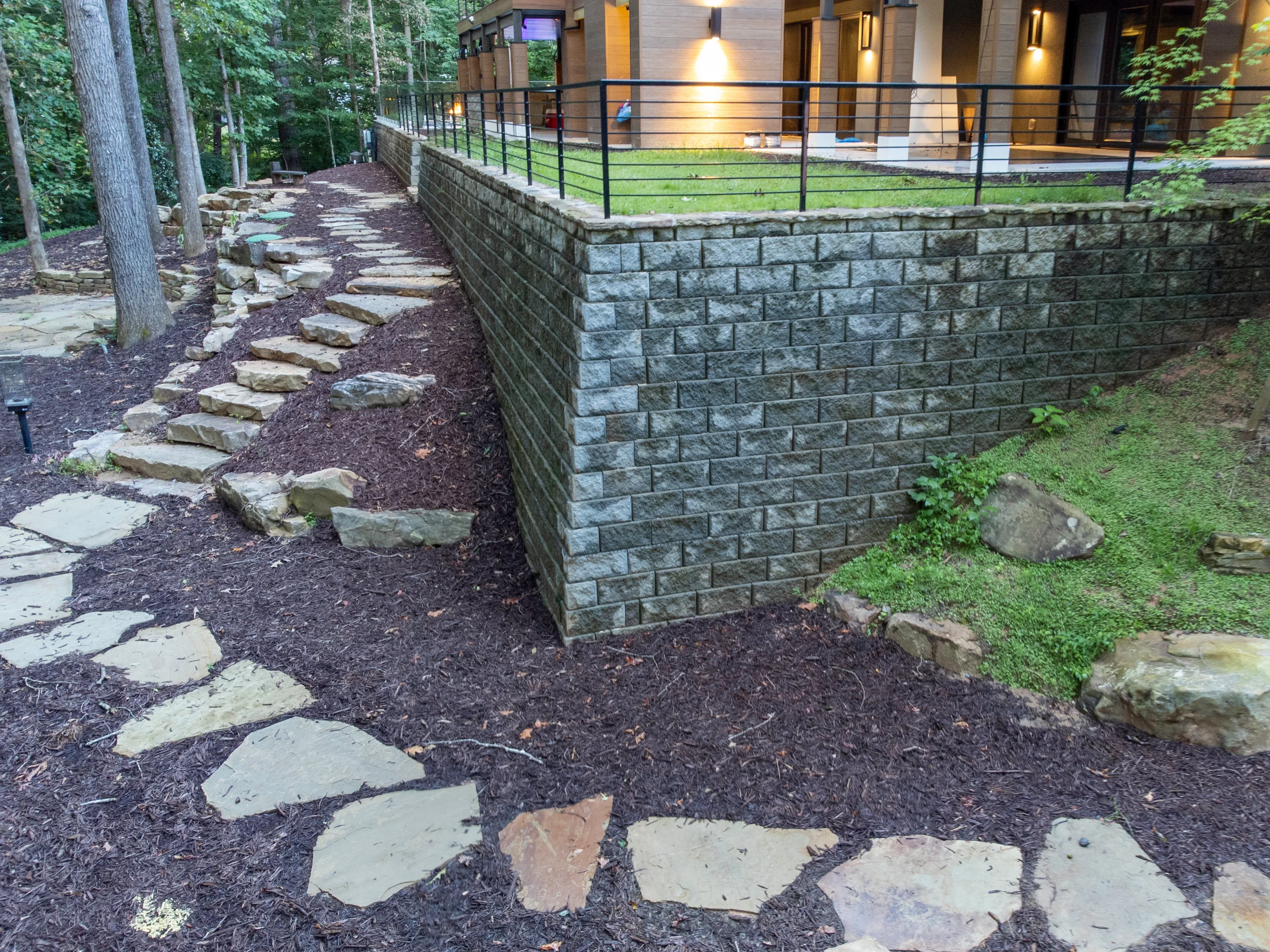 Segmental retaining wall with flagstone pathway and mulch in wooded residential setting