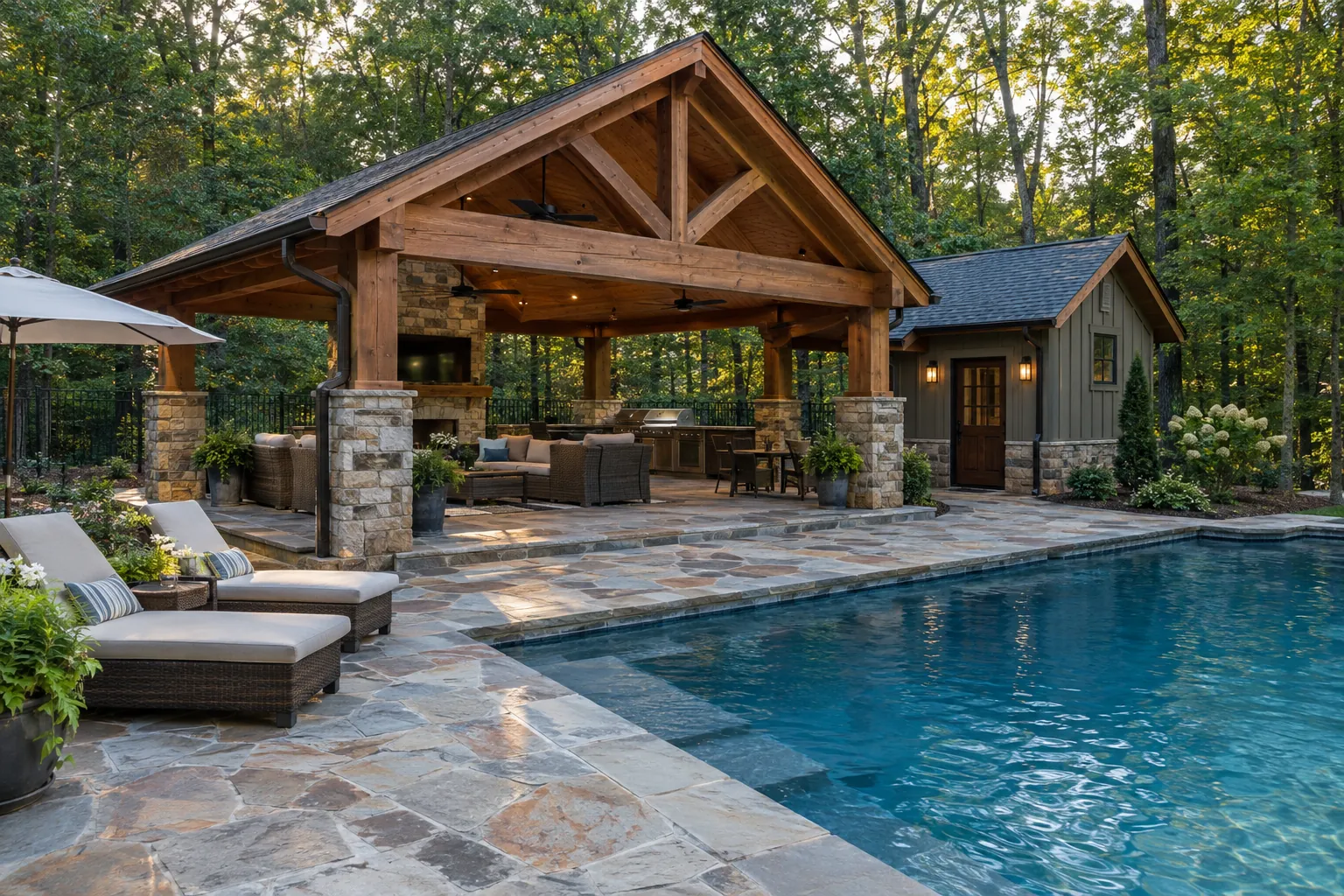 Timber pavilion with stone columns beside a pool and a small pool house