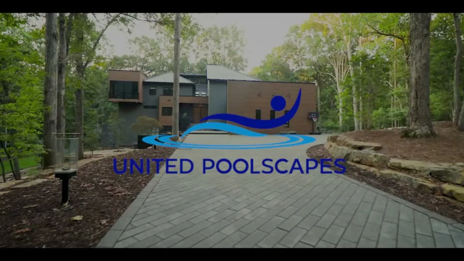 A finished backyard with a pool, outdoor kitchen and boulder walls video thumbnail