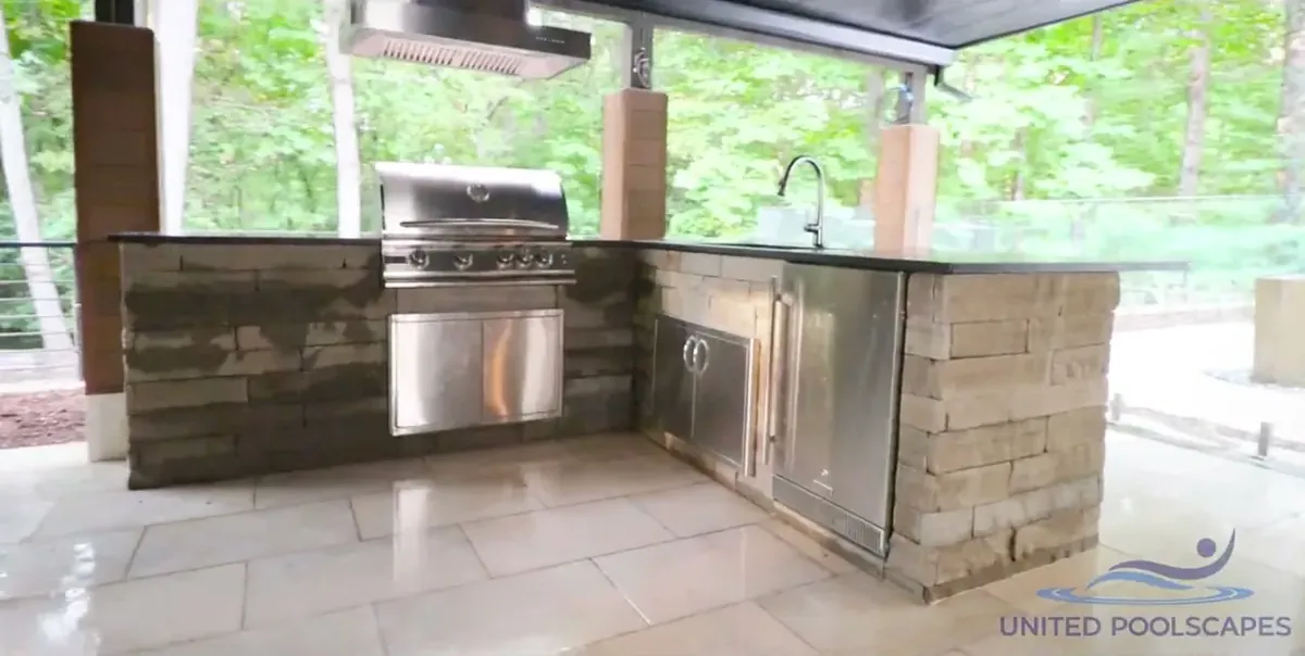 Covered outdoor kitchen with a grill, sink and storage